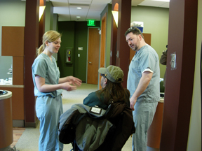 Dr. Amy Winston and dental assistant talk with a patient in a wheelchair.