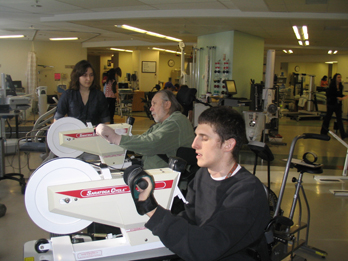 Two individuals with spinal cord injuries using ergometers.
