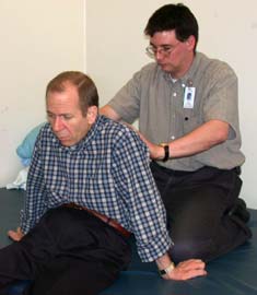 Figure 2: Physical therapist Dave Colescott takes several measurements, including hip width, back length and leg length, to ensure a proper fit for Hennig's new wheelchair.