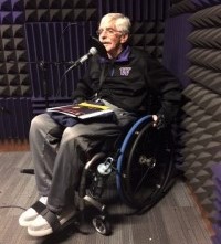 Lan Remme seated in a wheelchair recording poetry into a microphone