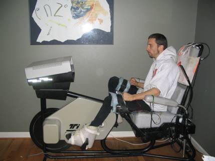 Person with C6 SCI demonstrates Ergys cycling machine.